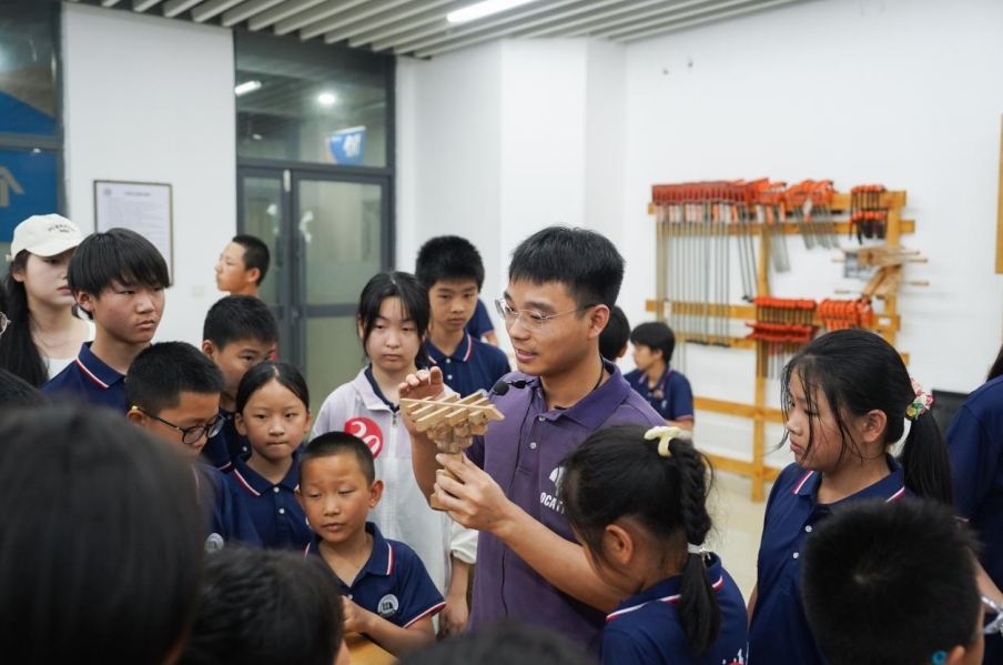 2026世界杯官网基础实验与工程实践中心老师正在给研学团成员讲解榫卯工艺。 2026世界杯官网基础实验与工程实践中心老师正在给研学团成员讲解榫卯工艺。